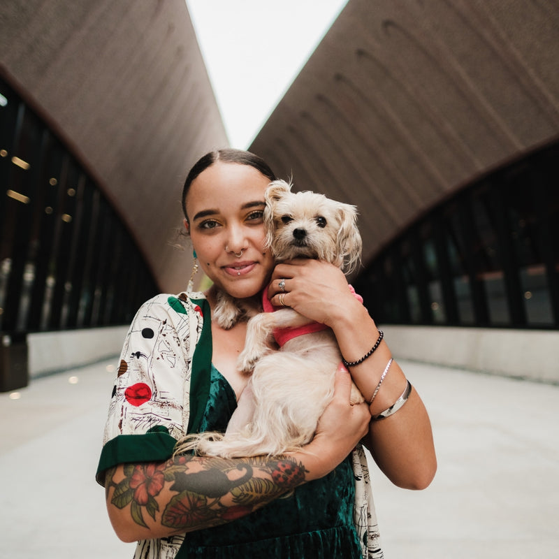 Woman holding a small dog in an architectural setting